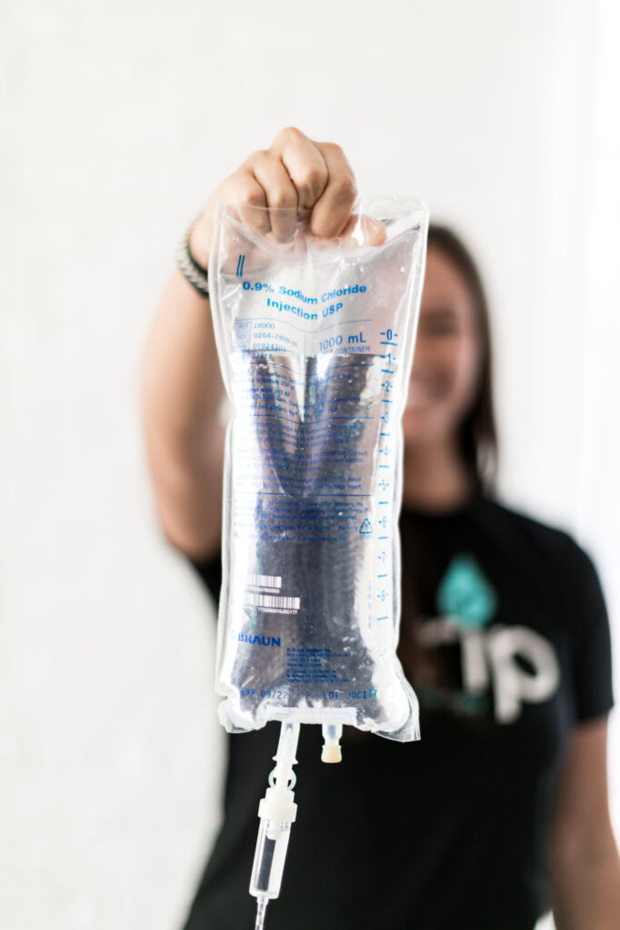 Saline Bag being held by a Drip IV Therapy Nurse